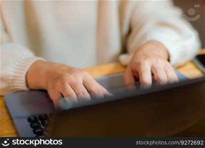 Woman sitting at desk and working on laptop in office at home close-up. Close up of woman hand using laptop sitting in office and doing research.