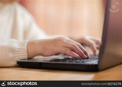 Woman sitting at desk and working on laptop in office at home close-up. Close up of woman hand using laptop sitting in office and doing research.