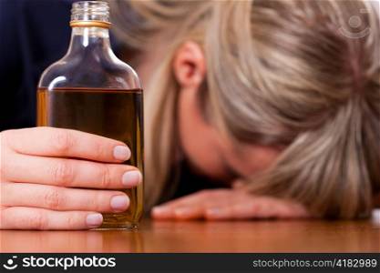 Woman sitting at home drinking way too much brandy, she is addicted