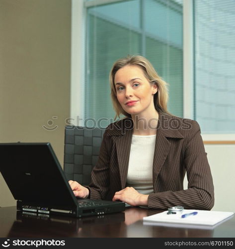 woman sitting at office desk using laptop computer