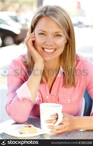 Woman sitting at sidewalk cafe