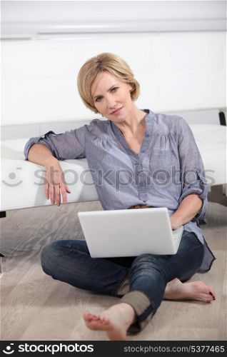 woman sitting bare-footed on the floor with laptop