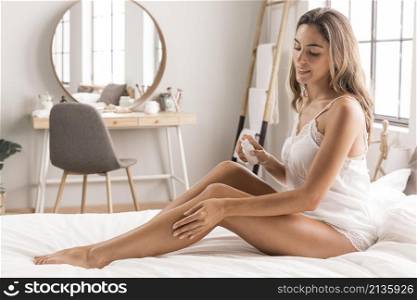 woman sitting bed massaging her legs