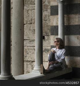 Woman sitting by columns at Amalfi Cathedral, Amalfi, Amalfi Coast, Salerno, Campania, Italy
