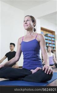 Woman sitting cross-legged in a yoga class