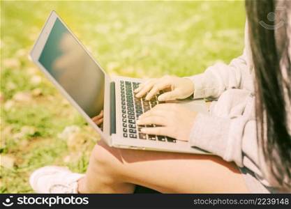 woman sitting green grass working laptop