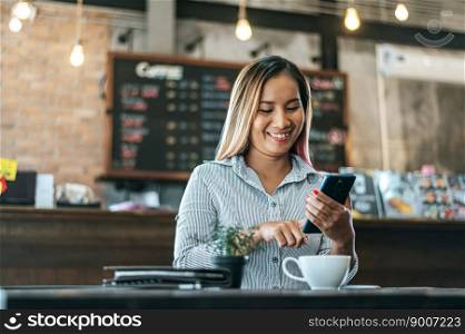 woman sitting happily working with a smartphone in a coffee shop