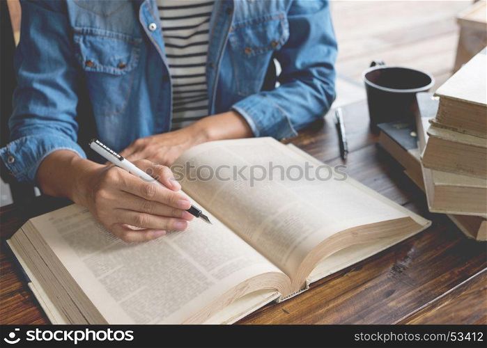 Woman sitting in a cafe, reading book.