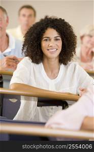 Woman sitting in adult classroom with students in background (selective focus)
