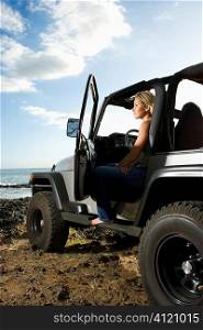 Woman Sitting in an SUV at the Beach