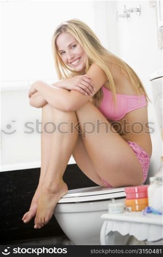 Woman sitting in bathroom