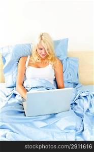Woman sitting in bed with computer
