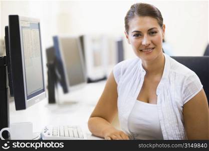 Woman sitting in computer room smiling