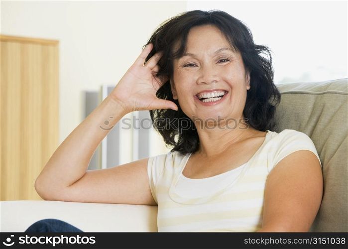 Woman sitting in living room laughing