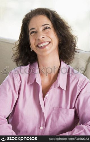 Woman sitting in living room smiling