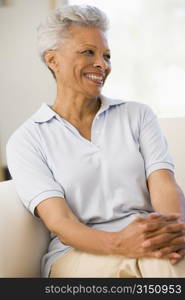 Woman sitting in living room smiling