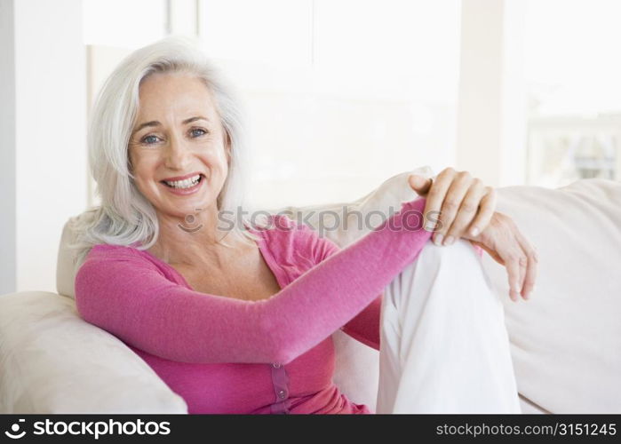 Woman sitting in living room smiling