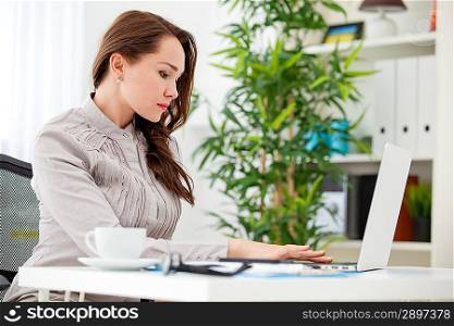 Woman sitting in offce and useing laptop