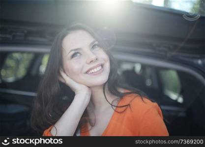 woman sitting in the trunk of the car of a young beautiful spring