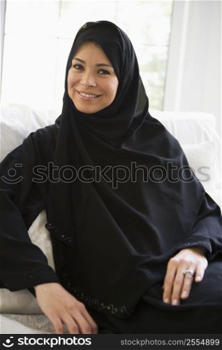 Woman sitting indoors smiling (high key)