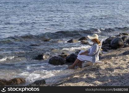 Woman sitting on a chair in front of ocean on beach. Summer holiday or vacation travel.
