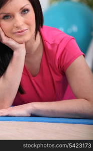 Woman sitting on a mat in a gym