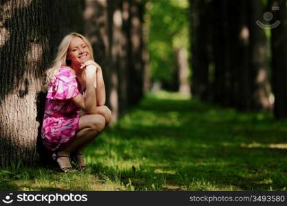 Woman sitting on a shady park alley