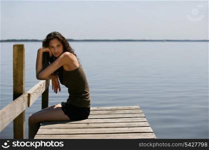 Woman sitting on a wooden pier