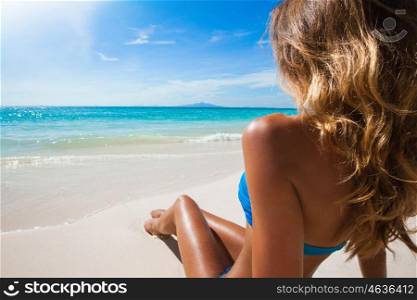 Woman sitting on beach. Woman in bikini sitting on the beach at sunny day