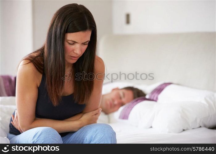 Woman Sitting On Bed And Feeling Unwell