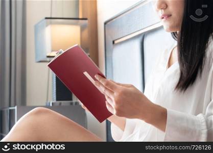 woman sitting on bed reading the book