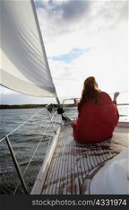 Woman sitting on bow of yacht