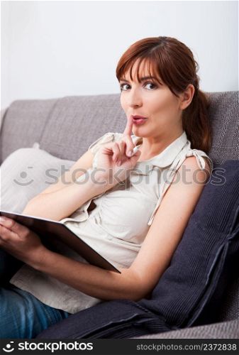 Woman sitting on couch at home, and asking silence