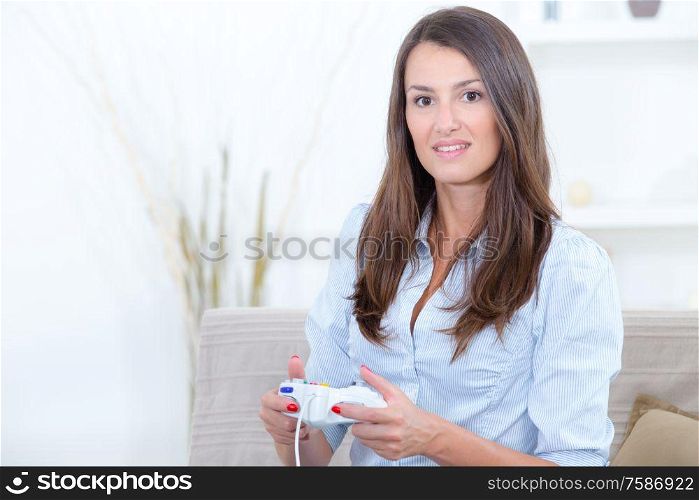 woman sitting on couch at home and playing video games