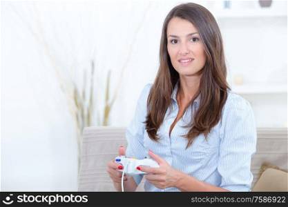 woman sitting on couch at home and playing video games