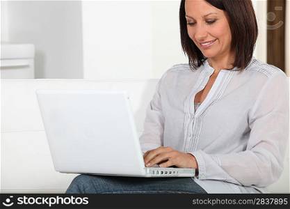 Woman sitting on couch with computer