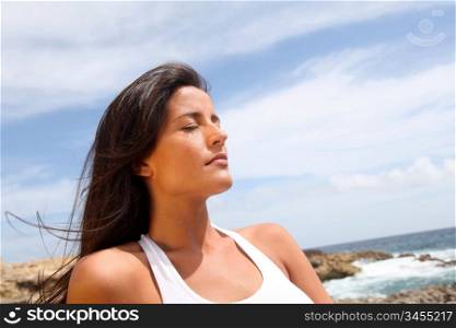 Woman sitting on rocks in fitness outfit