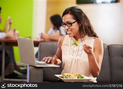 Woman Sitting On Sofa And Eating Lunch In Design Studio