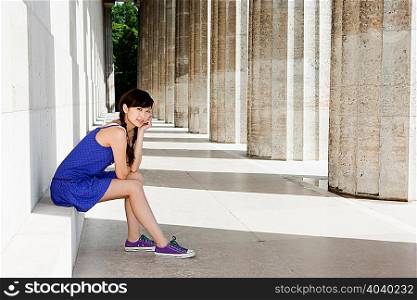 Woman sitting on stone step, Regensburg, Bavaria, Germany