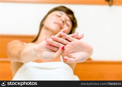 woman sitting on the bed with his eyes closed and stretches