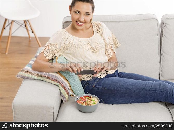 Woman sitting on the couch ready to eat and talking picture to her food