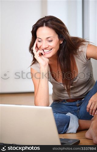 Woman sitting on the floor at home with laptop