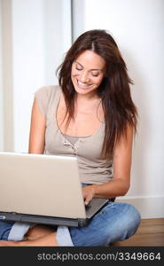 Woman sitting on the floor at home with laptop