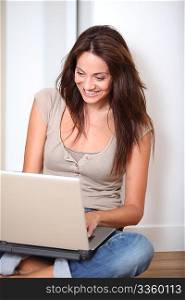 Woman sitting on the floor at home with laptop