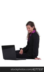 Woman sitting on the floor looking at computer