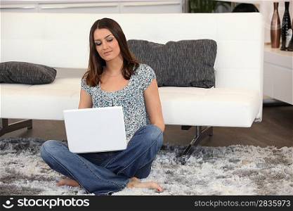 Woman sitting on the floor using a laptop computer