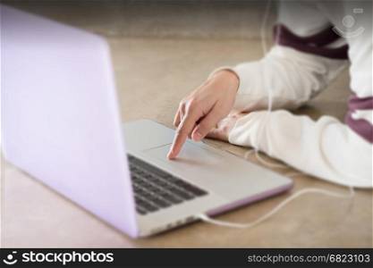 Woman sitting on the floor using laptop, stock photo