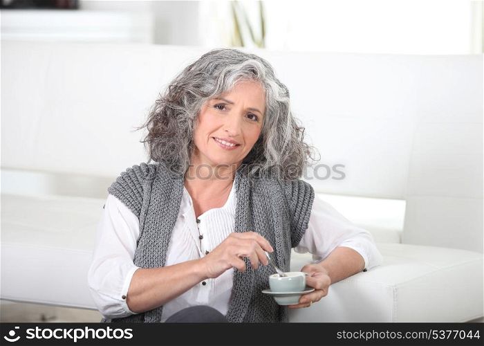 Woman sitting on the floor with a cup of coffee