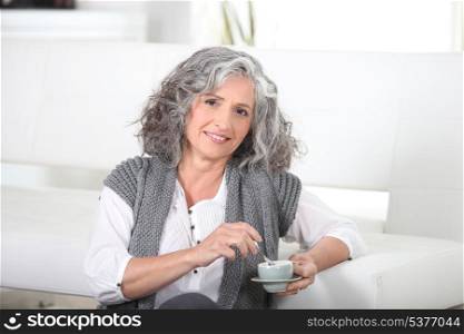 Woman sitting on the floor with a cup of coffee