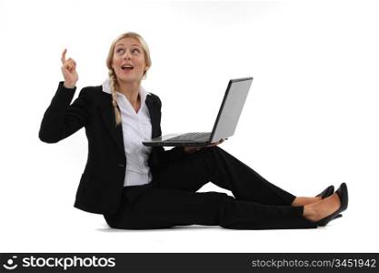 woman sitting on the floor with her laptop and having a great idea